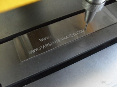 CNC-Fräsmaschine schneidet ein Metallteil mit eingraviertem Text.