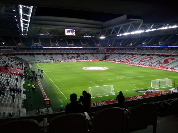 Großes Stadion voller Zuschauer bei einem Fußballspiel im Estadio Santiago Bernabeu in Madrid, Spanien, unter Stadionbeleuchtung mit einem Bildschirm oben.