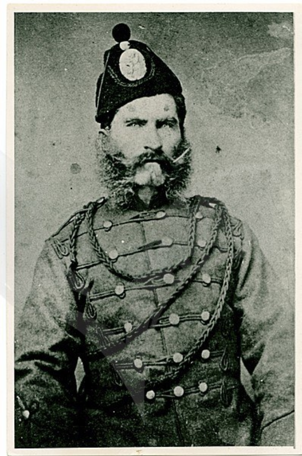 Altes Schwarz-Weiß-Foto eines bärtigen Mannes in militärischer Uniform mit Schirmmütze, strenger Miene und direktem Blick.