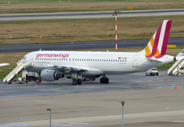 Ein Airbus A320-200 der Germanwings steht auf dem Frankfurter Flughafen, mit Fahrzeugen, Verkehrskegeln, Masten und Gras im Hintergrund.