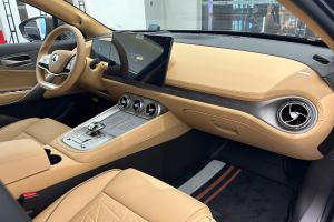 Das Innere eines Mercedes-Benz S-Klasse Limousinen auf der Internationalen Automobil-Ausstellung in Frankfurt, mit Lenkrad, Armaturenbrett, Bildschirmen, Knöpfen, Sitzen, Seitenspiegeln und Glasfenstern, durch die Menschen, Gebäude und andere Objekte im Hintergrund sichtbar sind.