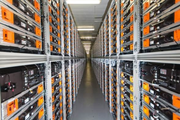 Eine lange Reihe von Servern in einem Rechenzentrum mit elektronischen Geräten in den Racks und Anzeigelichtern oben.