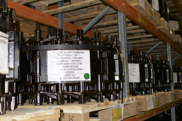 Ein Lagerraum voller Metallverteilergehäuse auf Holzpaletten, jedes mit einem Aufkleber markiert, der verschiedene Komponenten zeigt.