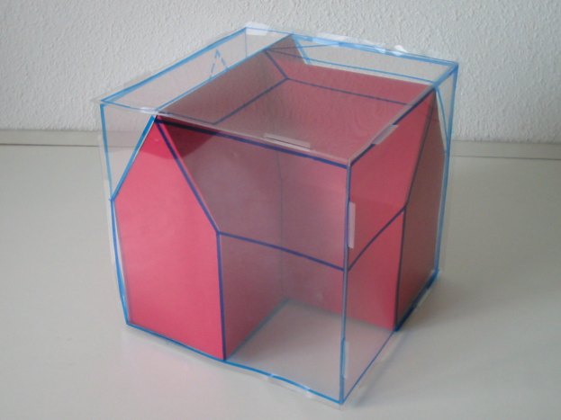 Ein pinkfarbener und blauer Wahlbriefkasten mit offenem Deckel, der auf einem weißen Tisch steht.