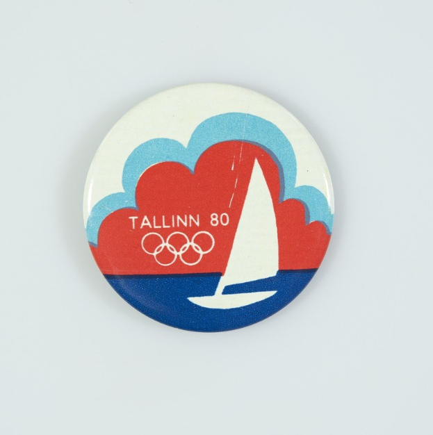 Ein weißer Abzeichen mit einem Segelboot-Design und dem Text "Tallinn 80 Olympische Spiele", zum 80. Jahrestag der Olympischen Spiele in Tallinn.