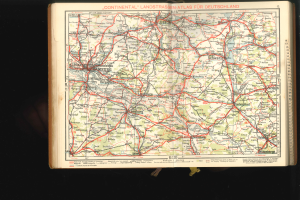 Ein aufgeschlagenes Buch, das eine detaillierte Karte von Deutschland mit Straßen und Autobahnen zeigt, vor einem dunklen Hintergrund.