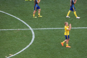 Eine Gruppe von Männern in Fußballtrikots steht auf einem Fußballfeld und klatscht in die Hände.
