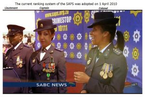 Gruppe von Menschen in Uniformen und Hüten, die mit einem Banner stehen, mit Text oben und unten, der besagt "Das aktuelle Rankingsystem der SAP wurde am 1. April 2010 übernommen".