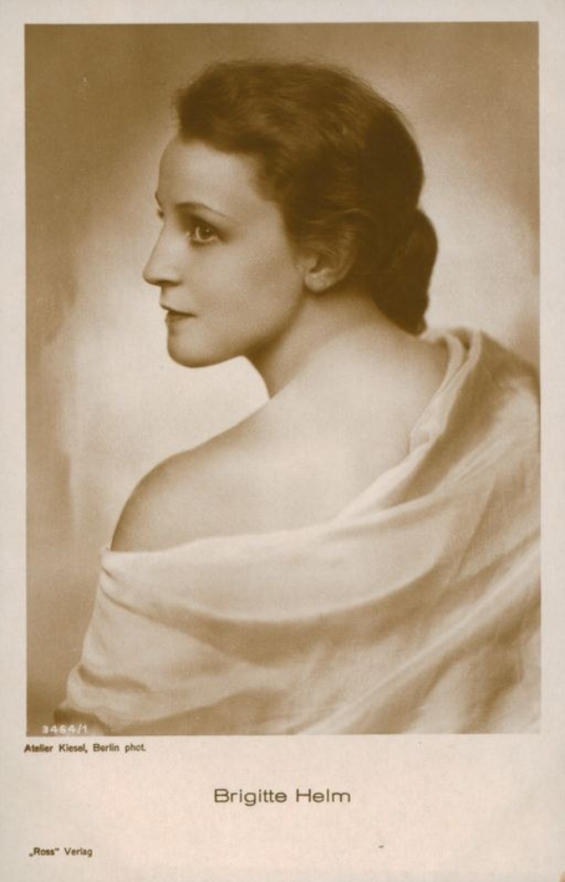 Schwarzes und weißes Porträt von Brigitte Helm, einer deutschen Schauspielerin, in einem weißen Kleid mit Text unten.